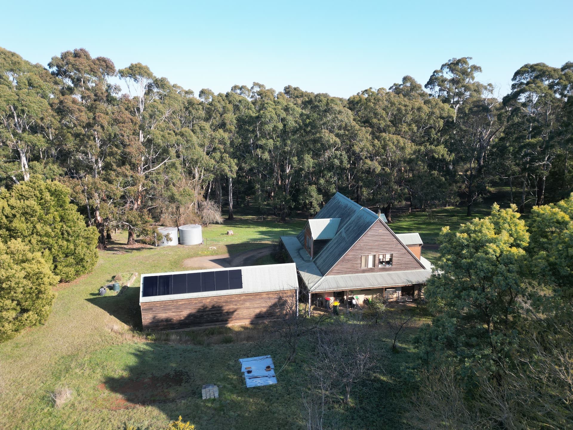 A completed solar array on a shed beside the house, tucked into the bush