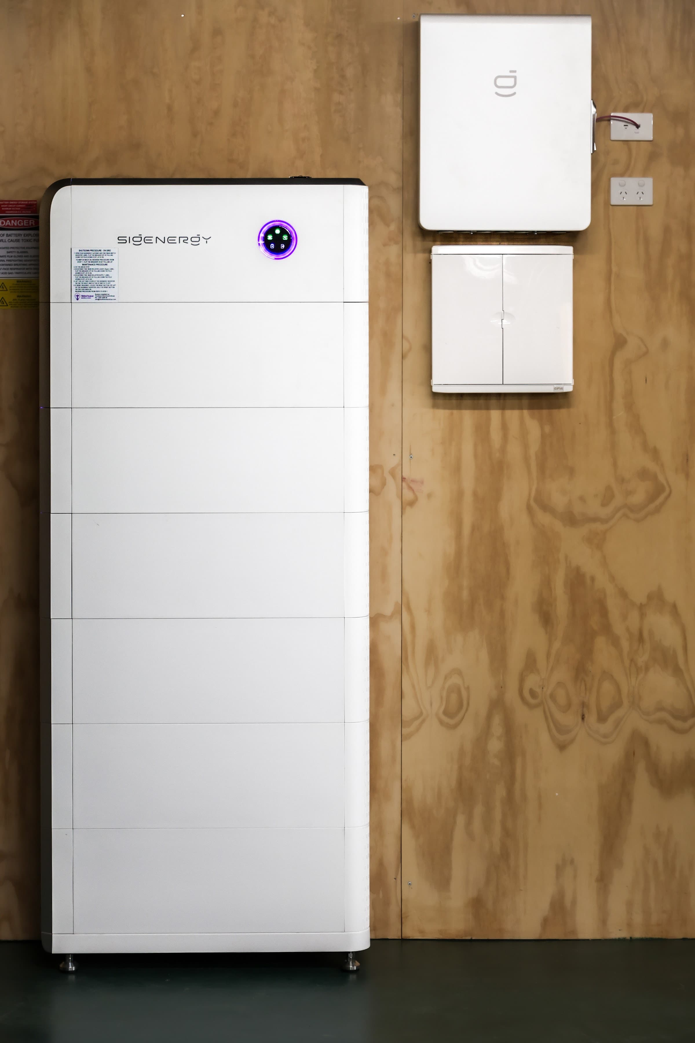 Battery cabinet and inverter mounted on the wall of a completed off-grid system